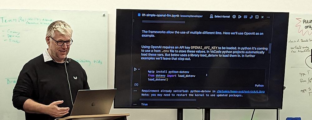 Patrick Debois at the Seattle Pulumi User Group, with a monitor showing OpenAI LangChain and code in Python